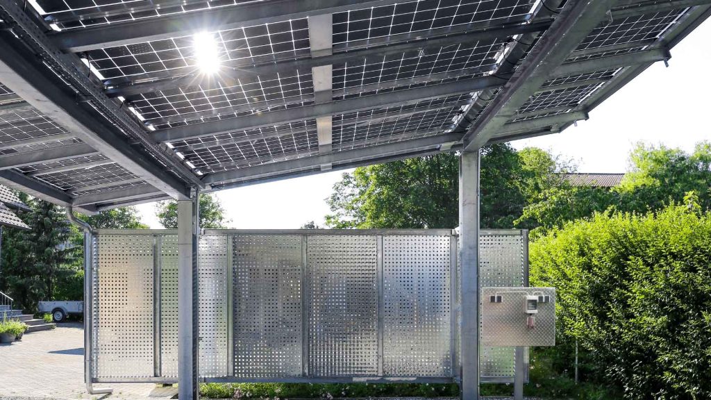 Carport structure with a solar panel roof and metal privacy screening