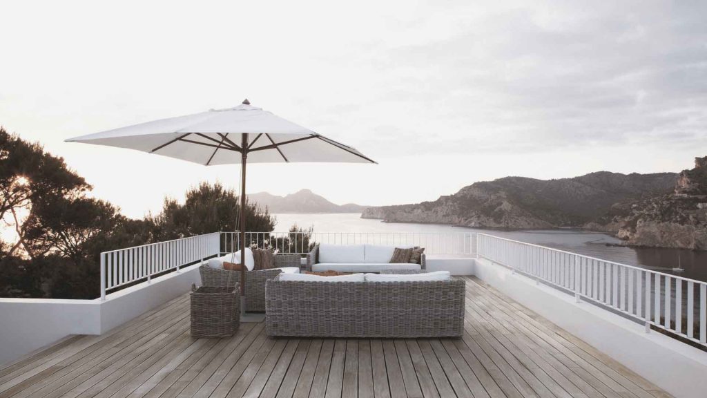 Timber deck with outdoor lounge furniture overlooking a coastal view