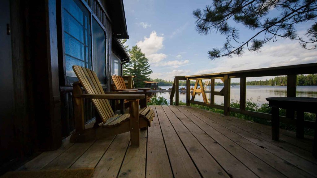 Timber deck with wooden armchairs overlooking a lake