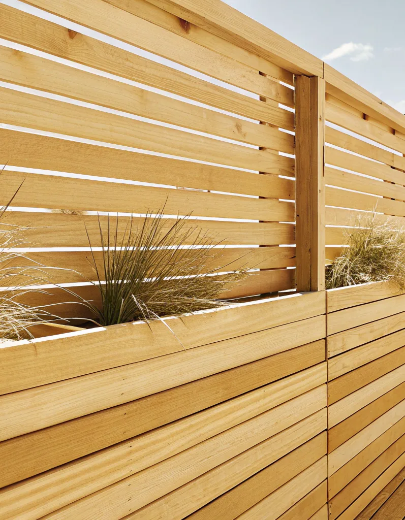 Timber slatted privacy screen with an integrated planter box on a deck