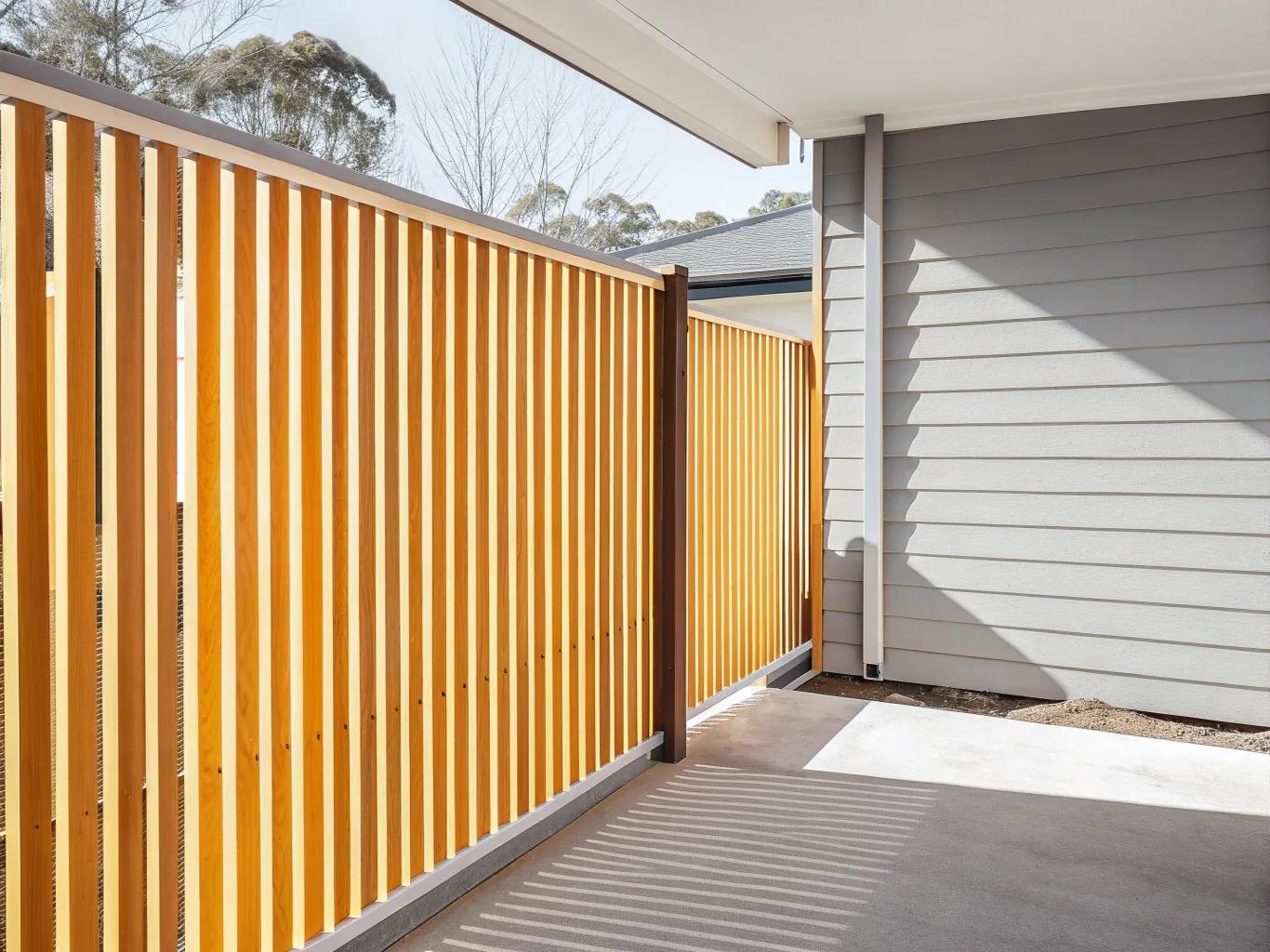 Vertical timber slat privacy screen beside a home's entry