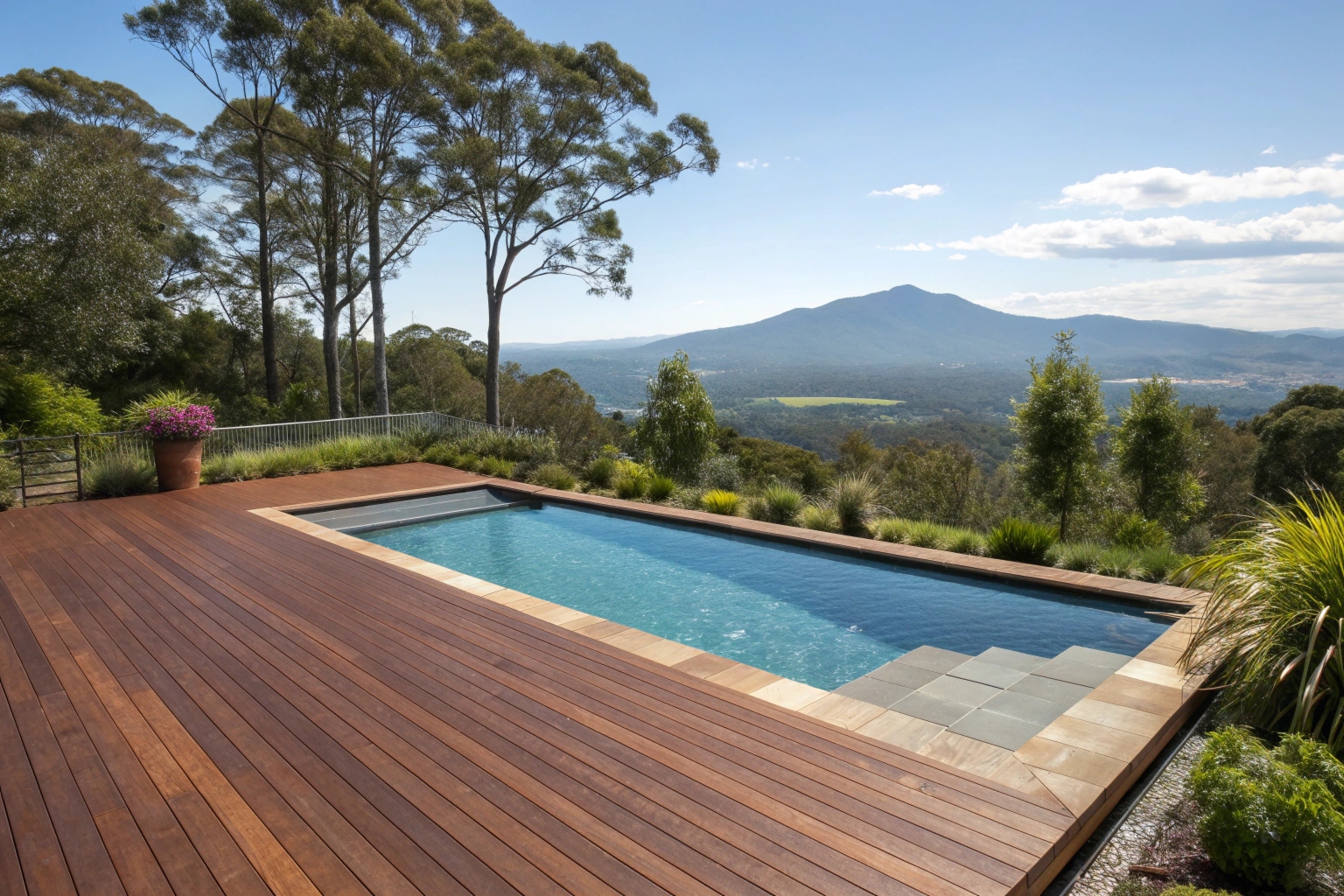 Rich brown timber pool deck surrounding a pool with mountain views